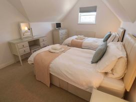 A bedroom with two beds and a desk at Meridian in Carbis Bay