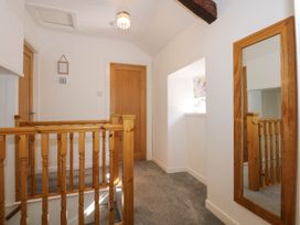 A hallway with wooden railings doors and a large wall mirror at Yr Hen Dy Capel in Blaenau Ffestiniog