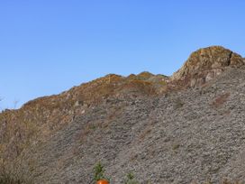 Rocky hillside with sparse vegetation under a clear blue sky at Yr Hen Dy Capel in Blaenau Ffestiniog