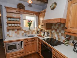 A kitchen with wooden cabinets and countertop at Cobbles House in Whitby