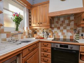 A kitchen with wooden cabinets and a sink at Cobbles House in Whitby