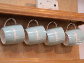 Mugs hanging on a rack in a kitchen at Cobbles House in Whitby