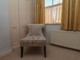 A chair near curtains and a radiator at Cobbles House in Whitby
