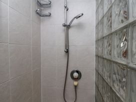 A shower area with a showerhead and shelf at Cobbles House in Whitby