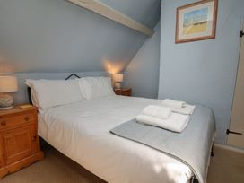 A bedroom with a bed and bedside tables at Cobbles House in Whitby
