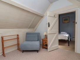A bedroom with a chair and a small table at Cobbles House in Whitby