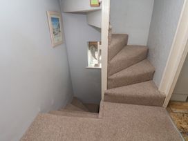 A staircase with carpet and a framed picture at Cobbles House in Whitby