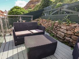 A garden with a sofa and coffee table at Cobbles House in Whitby