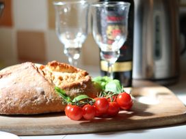 A kitchen scene with bread and tomatoes on a wooden board at Cobbles House in Whitby