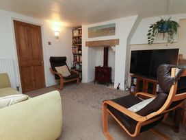 A living room with a chair and a television at Damson Cottage in Whitby