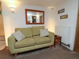A living room with a sofa and a mirror at Damson Cottage in Whitby