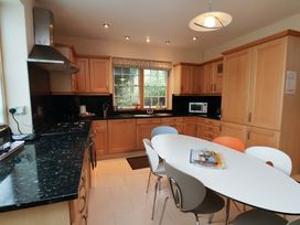 A kitchen with cabinets and an island table at Damson Cottage in Whitby