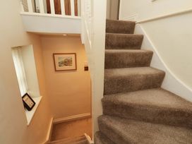 A stairway with a framed picture at Damson Cottage in Whitby