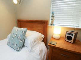 A bedroom with bed and nightstand at Damson Cottage in Whitby