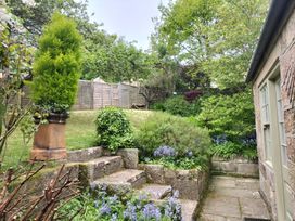 A garden with steps, hedges, and an access path at Damson Cottage in Whitby
