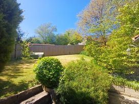 A garden with trees and grass at Damson Cottage in Whitby