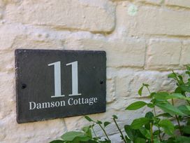 A house number and name plaque on a wall at Damson Cottage in Whitby