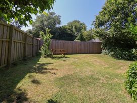 A garden with a bench and trees at Damson Cottage in Whitby