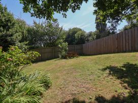 A garden with a bench and grass at Damson Cottage in Whitby