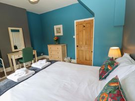 A bedroom with a bed and dresser at West End House in Whitby