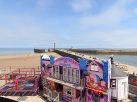 A beach with a house and pier at Beachfront Whitby