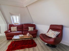 A living room with a couch and armchair at Beachfront in Whitby