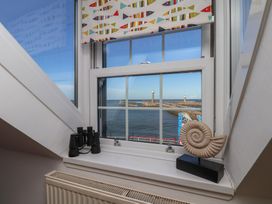 A view from a window with binoculars and a shell on a ledge at Beachfront in Whitby