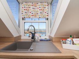 A kitchen with a sink and window view at Beachfront in Whitby