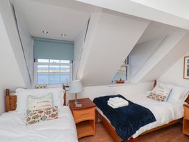 A bedroom with two beds and a window at Beachfront in Whitby