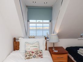 A bedroom with a bed and window view at Beachfront in Whitby