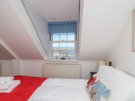 A bedroom with a bed and window view of the sea at Beachfront in Whitby