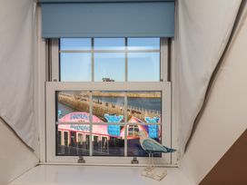 A window with a bird figurine overlooking a waterfront view at Beachfront Whitby