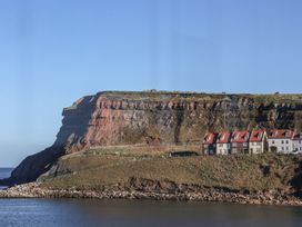 A cliff with houses near the ocean at Beachfront in Whitby