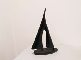 A black abstract sculpture resembling a sail on display