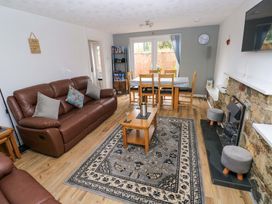 A living room with a sofa and dining table at Ty'r Winllan in Newport, Pembrokeshire