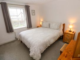 A bedroom with a bed and nightstands at Ty'r Winllan in Newport, Pembrokeshire