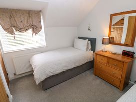 A bedroom with a single bed and a dresser at Ty'r Winllan in Newport, Pembrokeshire