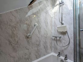 A bathroom with a shower and bathtub at The Smithy in Dulas