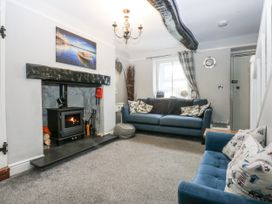 A living room with furniture and a fireplace at Tan Yr Allt Chwilog