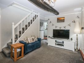 A living room with a sofa and television at Tan Yr Allt in Chwilog