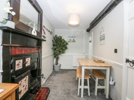 A dining room with a table and benches at Tan Yr Allt in Chwilog