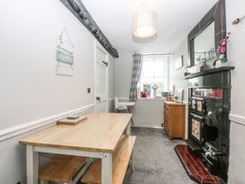 A dining room with a table and chairs at Tan Yr Allt in Chwilog