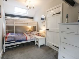 A bedroom with a bunk bed and a nightstand at Tan Yr Allt in Chwilog