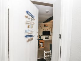A living room with a television and coffee table at Tan Yr Allt in Chwilog