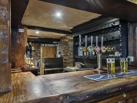 A bar counter with beer taps and glasses of beer at The Old Church House in Torbryan