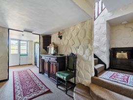 A hallway with a table and stairs at The Old Church House in Torbryan