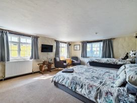 A bedroom with two beds and a television at The Old Church House in Torbryan