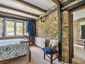 A bedroom with a bed, chair, and wardrobe at The Old Church House in Torbryan