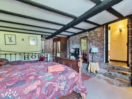 A bedroom with a bed and a mirror at The Old Church House in Torbryan