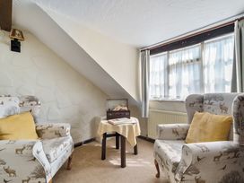 A snug with two armchairs and a small table at The Old Church House in Torbryan